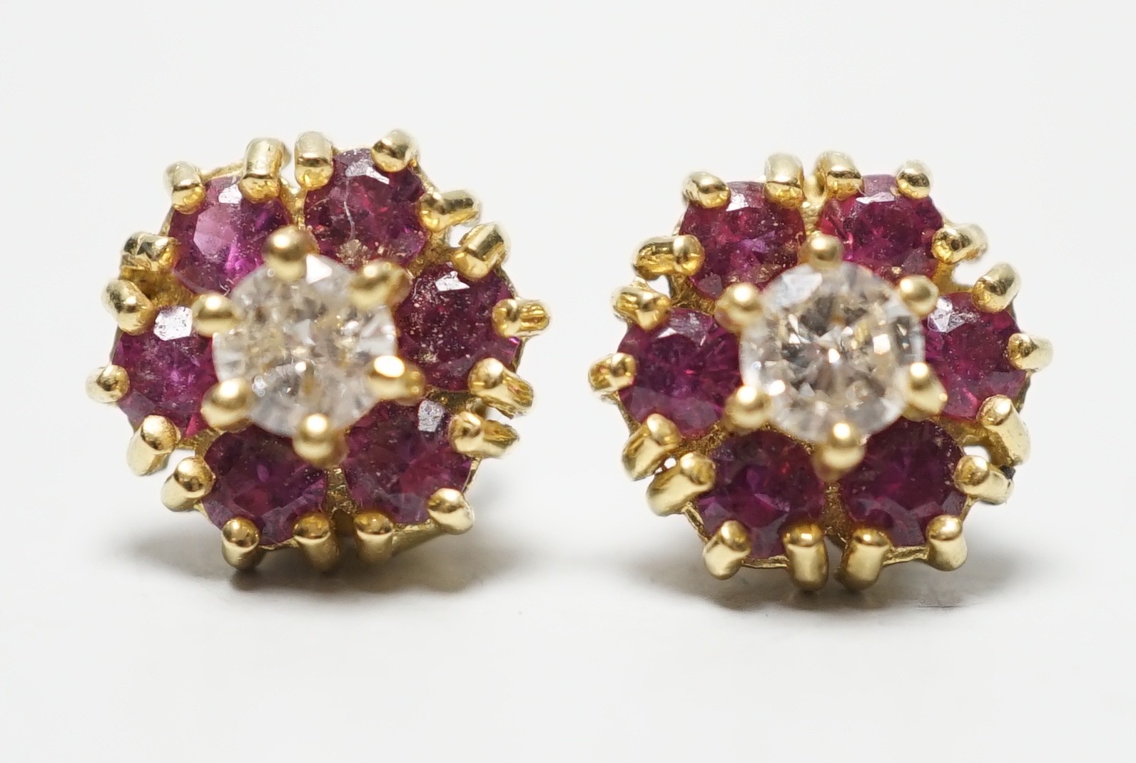A pair of 18ct gold, diamond and garnet? circular cluster ear studs, 9mm, gross weight 4 grams.